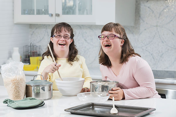 Two sisters with down syndrome in the kitchen